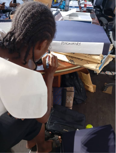 TeamO staff writing names on arranged WACP files inside boxes for easy physical retrieval
